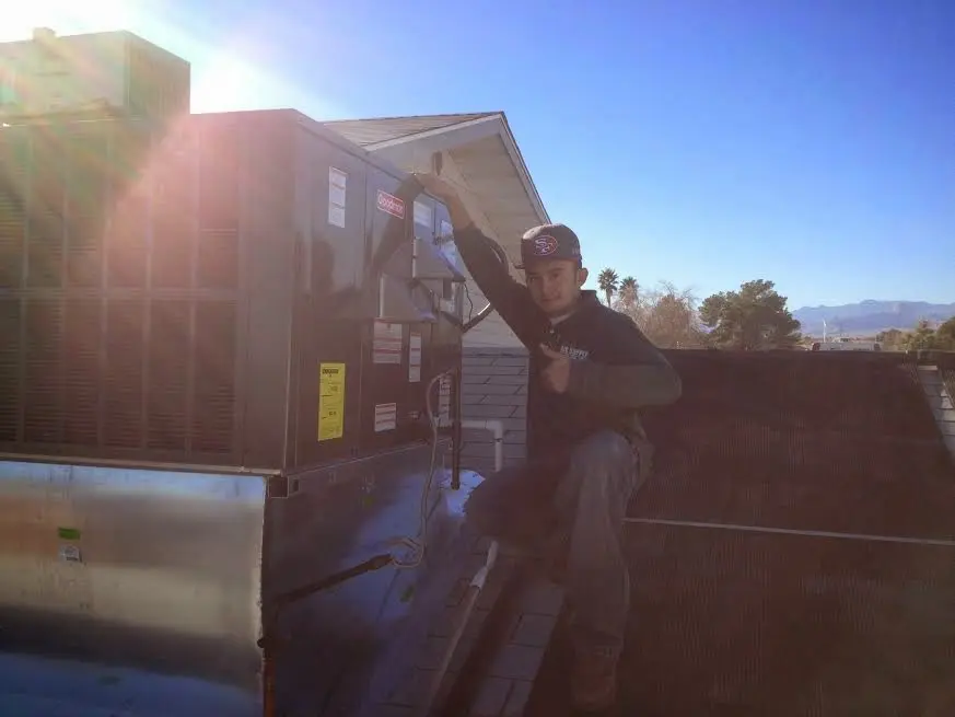 HVAC technician performing Boiler Repair on a rooftop unit in Colesville